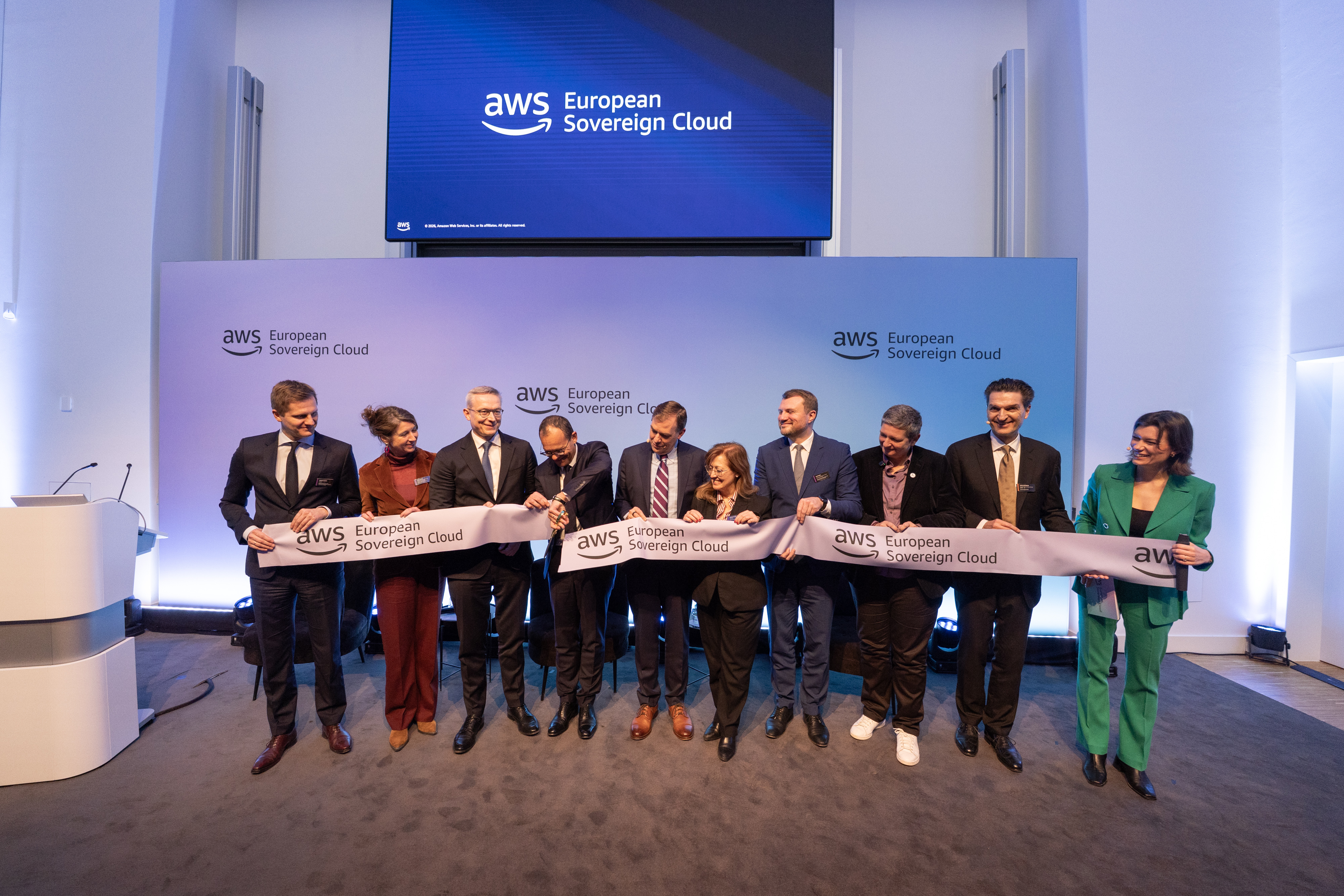 Bild zeigt mehrere Personen, die bei einer Feier ein Band durchschneiden